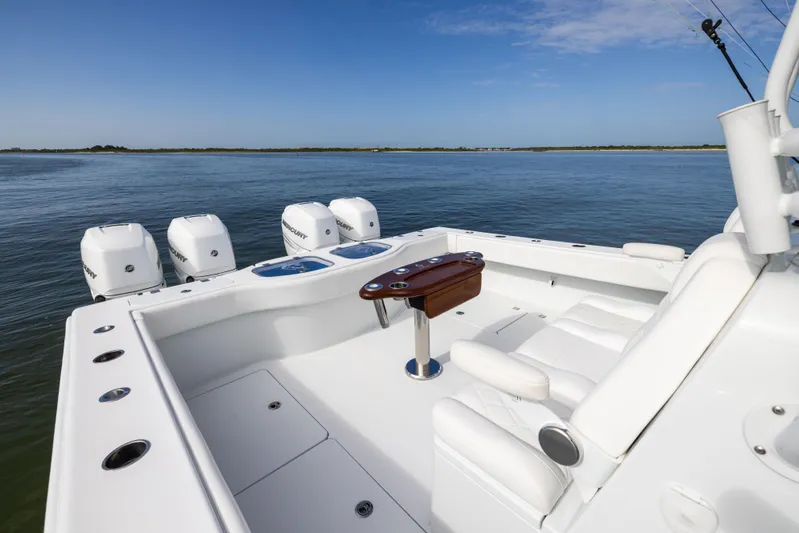  Yacht Photos Pics 2023 Freeman 42 LR boat deck with seating and multiple outboard engines on calm water.