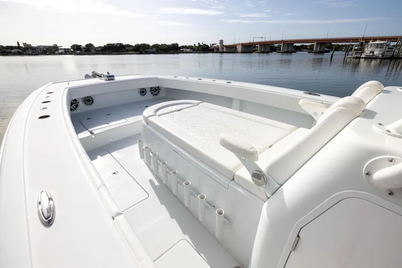  Yacht Photos Pics 2023 Freeman 42 LR boat interior with seating and rod holders, docked by a calm waterfront.