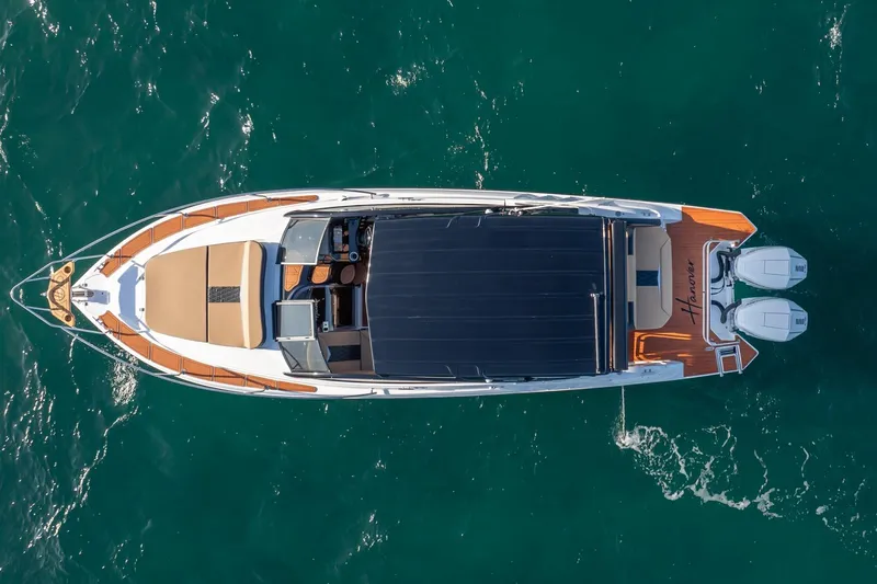  Yacht Photos Pics Aerial view of 2026 Hanover 305 luxury boat cruising on clear blue water.