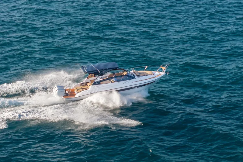  Yacht Photos Pics 2026 Hanover 305 boat cruising on open sea, creating white water trails.