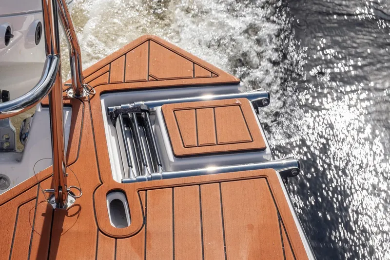  Yacht Photos Pics 2026 Hanover 305 boat deck with wooden finish and chrome details on water.