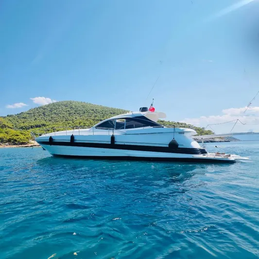  Yacht Photos Pics 2002 Pershing 54 yacht on clear blue water with scenic island backdrop.