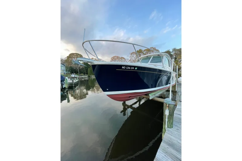 Old Fashioned (reserved) Yacht Photos Pics 2011 Back Cove 29 boat docked, reflecting on calm water under a cloudy sky.