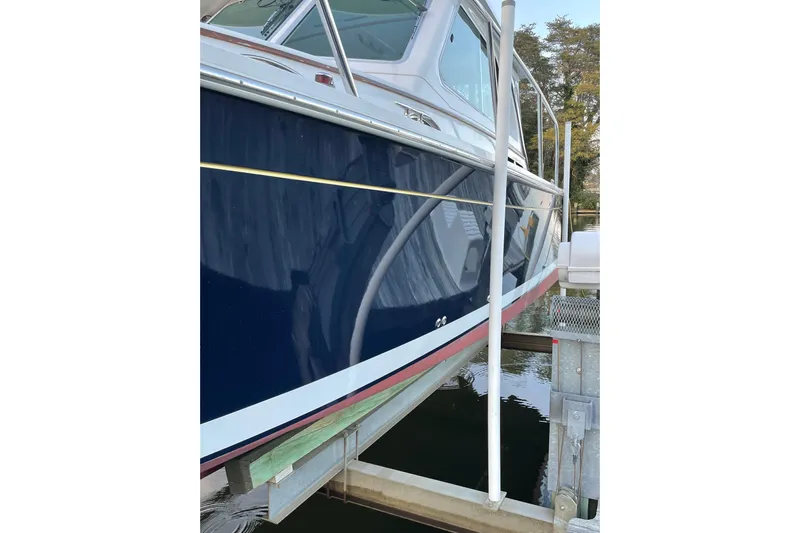 Old Fashioned (reserved) Yacht Photos Pics 2011 Back Cove 29 boat on lift, showcasing sleek blue hull and white trim.