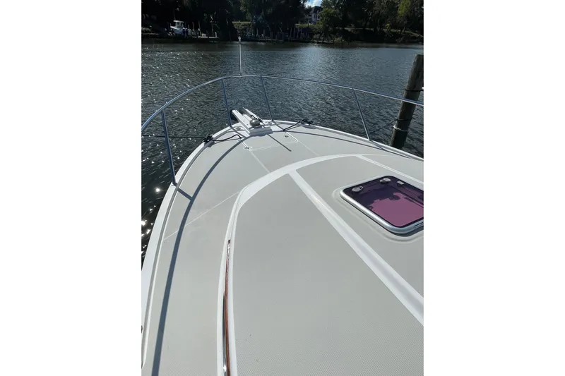 Old Fashioned (reserved) Yacht Photos Pics 2011 Back Cove 29 boat deck with railing, docked on calm water.