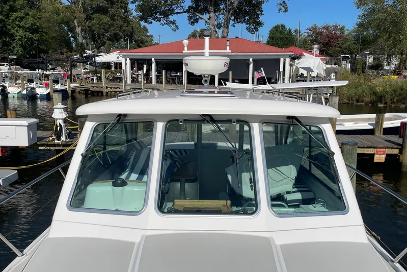 Old Fashioned (reserved) Yacht Photos Pics 2011 Back Cove 29 boat docked at a marina with a red-roofed building in the background.