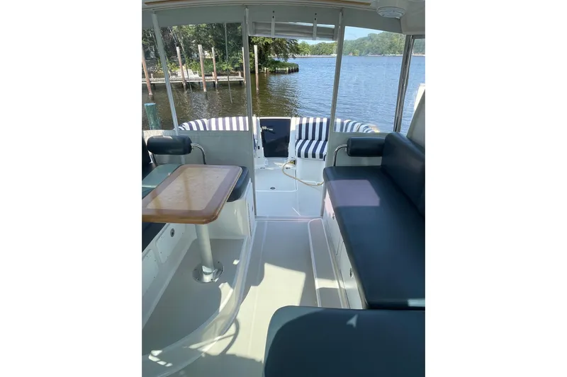 Old Fashioned (reserved) Yacht Photos Pics 2011 Back Cove 29 boat interior with seating, table, and water view.