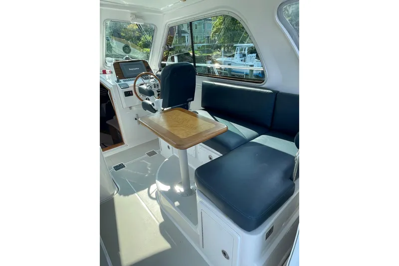 Old Fashioned (reserved) Yacht Photos Pics Interior of 2011 Back Cove 29 boat with helm, seating, and table.