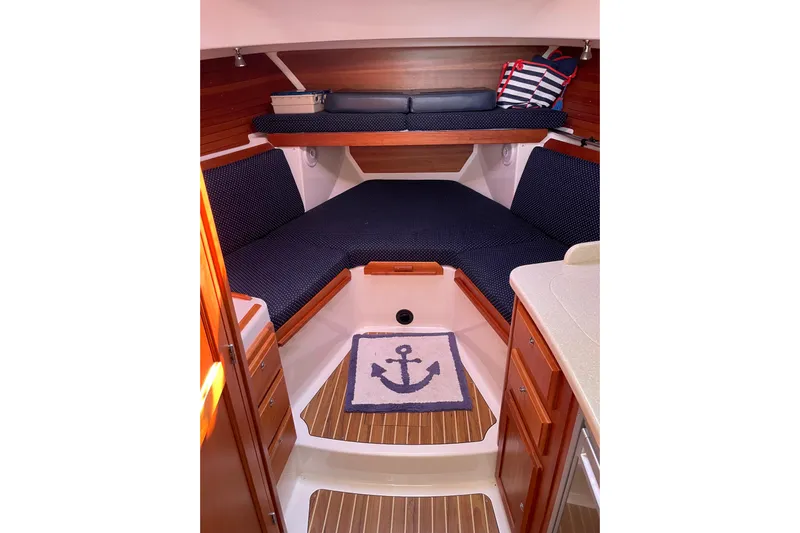 Old Fashioned (reserved) Yacht Photos Pics 2011 Back Cove 29 boat interior with cozy cabin, anchor-themed rug, and wooden accents.