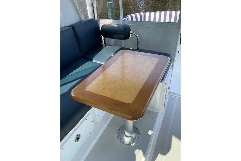 Old Fashioned (reserved) Yacht Photos Pics Interior of 2011 Back Cove 29 boat with wooden table and seating area.