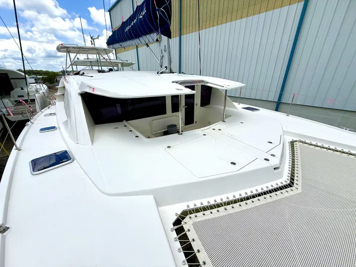 Diastema Yacht Photos Pics 2016 Leopard 44 catamaran with spacious deck and netting, docked near a warehouse.