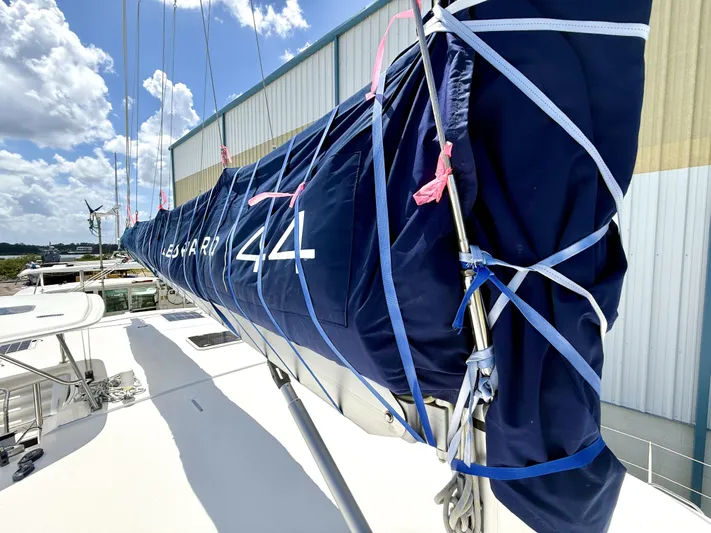 Diastema Yacht Photos Pics Sailboat Leopard 44, 2016 model, with blue sail cover, docked under a sunny sky.