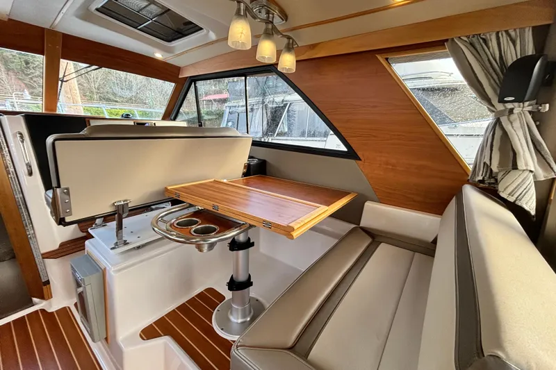  Yacht Photos Pics Interior of 2021 Cutwater C-32 CB yacht with wooden table and seating area.