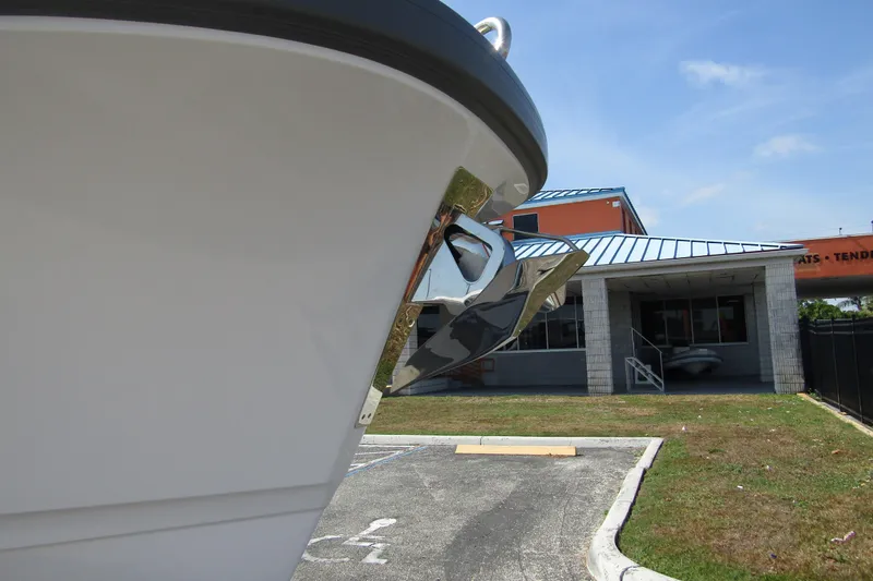  Yacht Photos Pics 2025 Nimbus Commuter 11 boat with anchor, parked near a building under a clear sky.