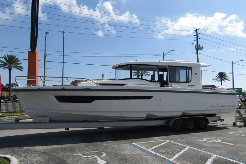  Yacht Photos Pics 2025 Nimbus Commuter 11 boat on trailer, parked outdoors under clear sky.