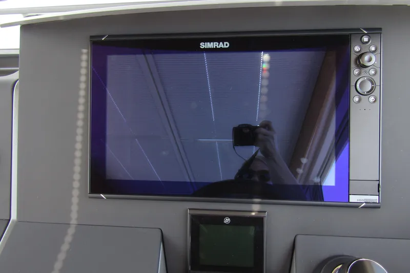  Yacht Photos Pics Simrad display on 2025 Nimbus Commuter 11 dashboard, featuring control buttons and screen reflection.