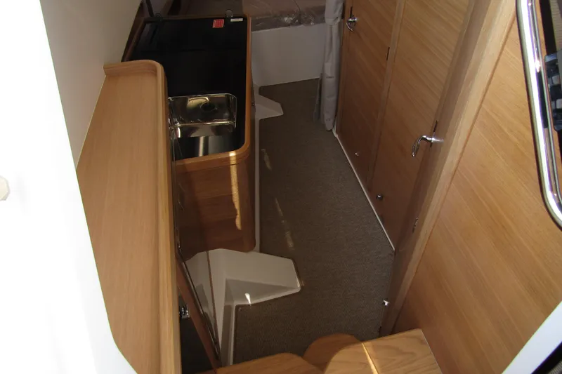  Yacht Photos Pics Interior of 2025 Nimbus Commuter 11 boat with wooden cabinetry and compact sink.