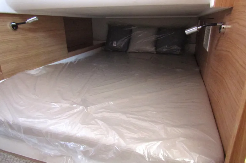  Yacht Photos Pics Cozy cabin bed in 2025 Nimbus Commuter 11, featuring wooden panels and reading lights.