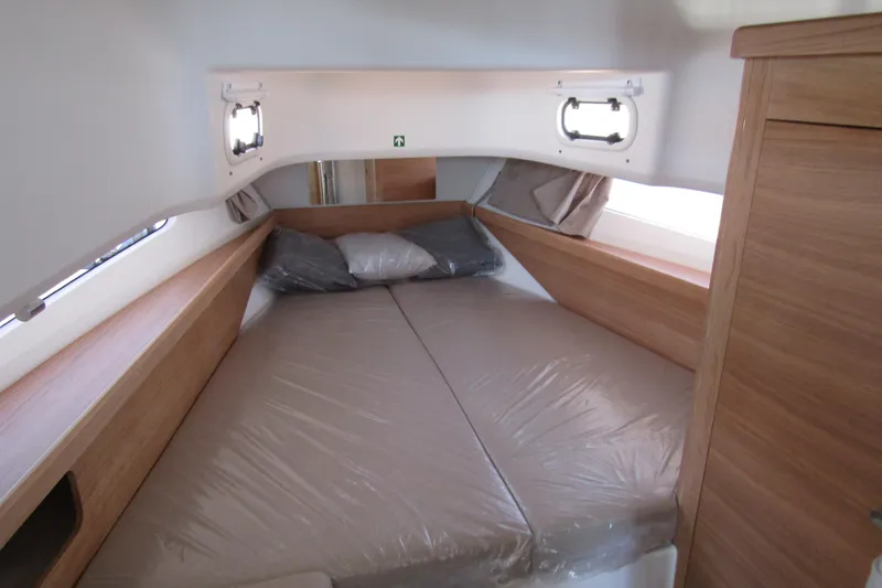  Yacht Photos Pics Cozy cabin interior of 2025 Nimbus Commuter 11 with wooden accents and comfortable bedding.