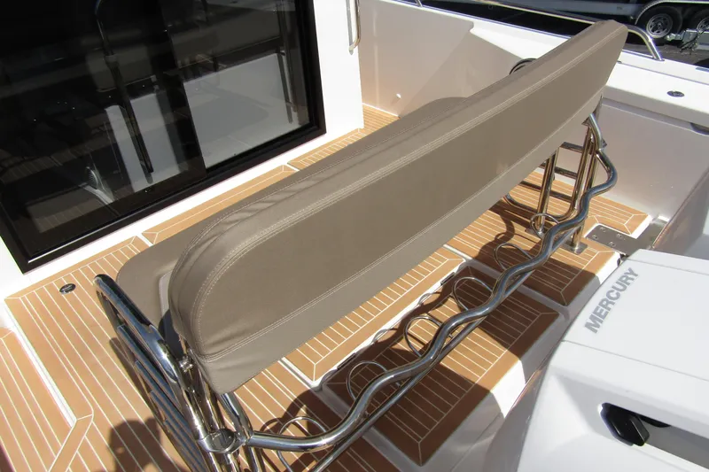  Yacht Photos Pics 2025 Nimbus Commuter 11 boat interior with cushioned seating and teak flooring.
