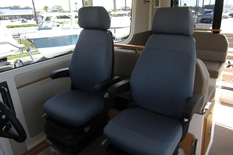  Yacht Photos Pics Interior of 2025 Nimbus Commuter 11, featuring two comfortable captain's chairs.