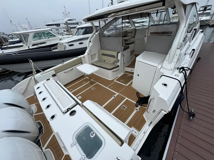  Yacht Photos Pics 2019 Pursuit DC 365 Dual Console boat docked, featuring spacious deck and seating area.