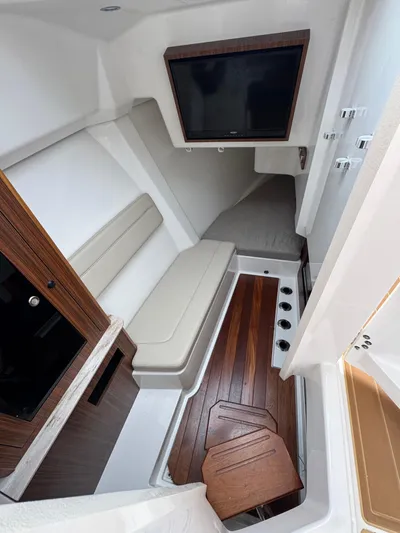  Yacht Photos Pics 2019 Pursuit DC 365 Dual Console cabin with TV, seating, and wooden flooring.