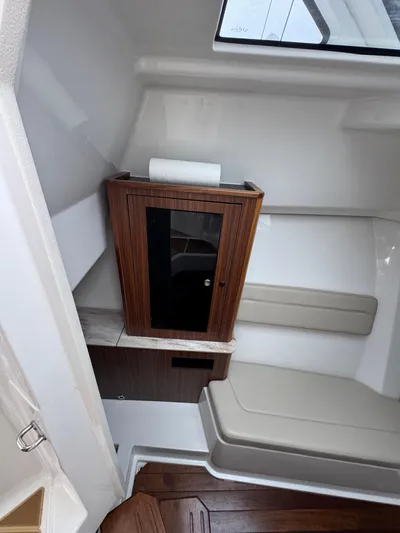  Yacht Photos Pics 2019 Pursuit DC 365 Dual Console interior with wooden cabinet and cushioned seating.