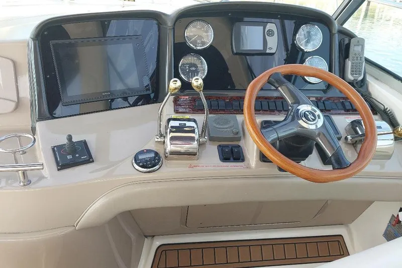 Cavok Yacht Photos Pics 2004 Sea Ray 420 Sundancer helm with wooden steering wheel and navigation controls.
