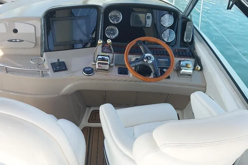 Cavok Yacht Photos Pics 2004 Sea Ray 420 Sundancer helm with wooden steering wheel and modern controls.