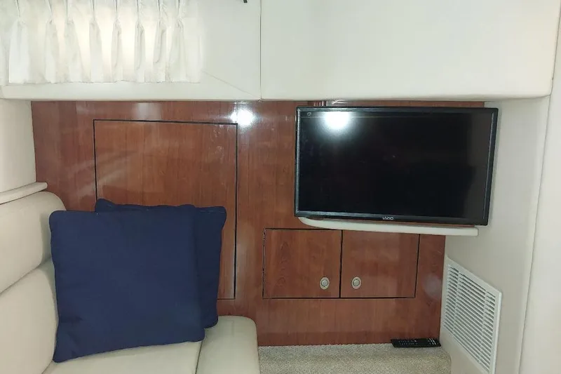 Cavok Yacht Photos Pics Interior of 2004 Sea Ray 420 Sundancer with TV, wood paneling, and blue cushion.