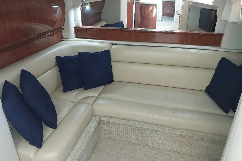Cavok Yacht Photos Pics Luxurious interior of 2004 Sea Ray 420 Sundancer with beige leather seating and blue cushions.