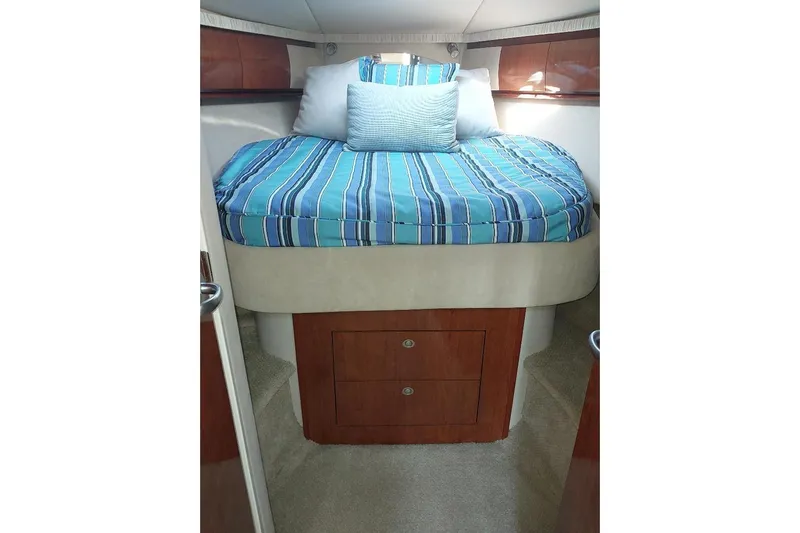 Cavok Yacht Photos Pics Interior cabin of 2004 Sea Ray 420 Sundancer with striped bedding and wooden storage.