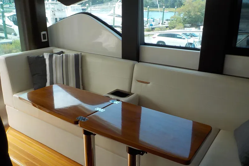 "double Dimond" Yacht Photos Pics Interior of 2018 Tiara Yachts 39 Coupe with elegant seating and wooden table.