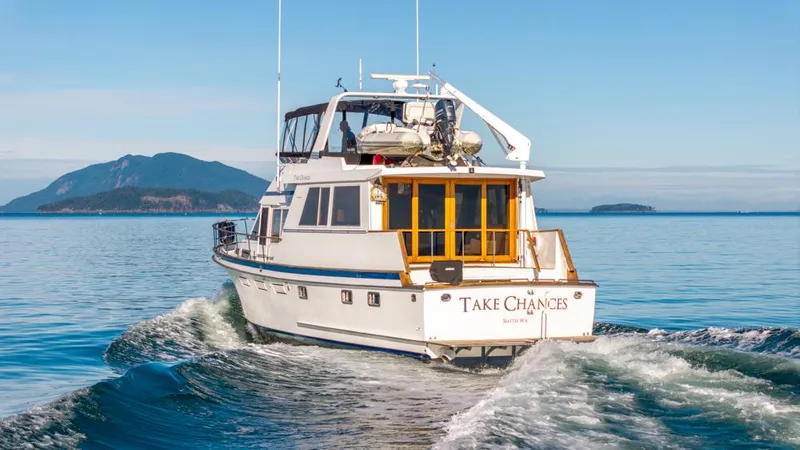 Take Chances Yacht Photos Pics 1986 Ocean Alexander Cockpit M/Y cruising on open water with scenic island backdrop.