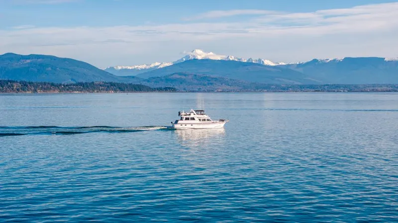 Take Chances Yacht Photos Pics Ocean Alexander 1986 Cockpit M/Y cruising on serene waters with mountain backdrop.
