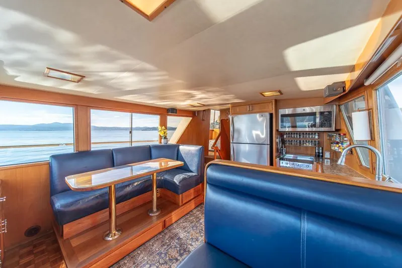 Take Chances Yacht Photos Pics Luxurious interior of 1986 Ocean Alexander Cockpit M/Y yacht with blue seating and kitchen area.