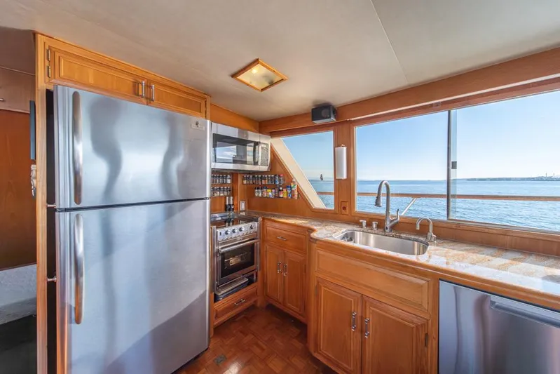 Take Chances Yacht Photos Pics 1986 Ocean Alexander Cockpit M/Y kitchen with ocean view, stainless steel appliances, and wooden cabinetry.