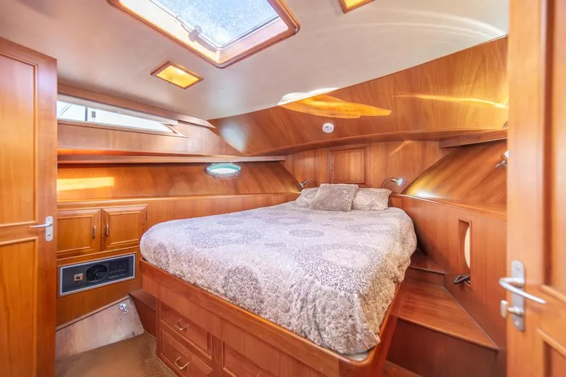 Take Chances Yacht Photos Pics Luxurious 1986 Ocean Alexander Cockpit M/Y cabin with wood paneling and cozy bedding.