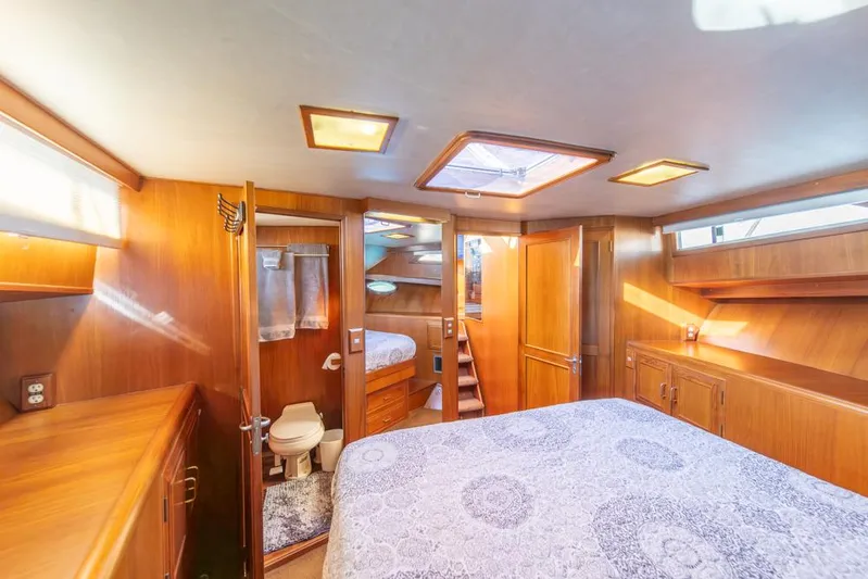 Take Chances Yacht Photos Pics Luxurious 1986 Ocean Alexander Cockpit M/Y cabin with wood paneling and cozy bedding.