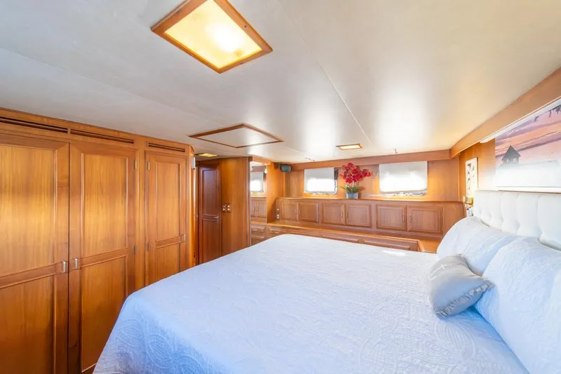 Take Chances Yacht Photos Pics Luxurious bedroom interior of 1986 Ocean Alexander Cockpit M/Y yacht with wood paneling.