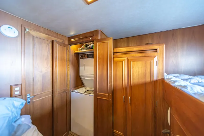 Take Chances Yacht Photos Pics Laundry area in 1986 Ocean Alexander Cockpit M/Y with wooden cabinetry and washer-dryer unit.