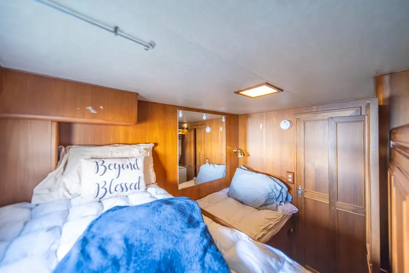 Take Chances Yacht Photos Pics Cozy cabin interior of 1986 Ocean Alexander Cockpit M/Y with wooden paneling and bedding.