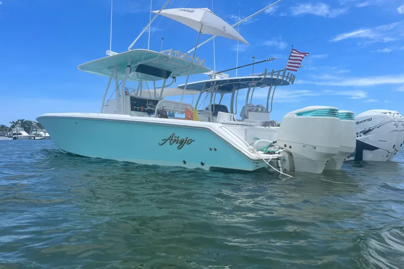  Yacht Photos Pics 2009 Venture 34 Tournament boat on water, American flag, clear sky background.