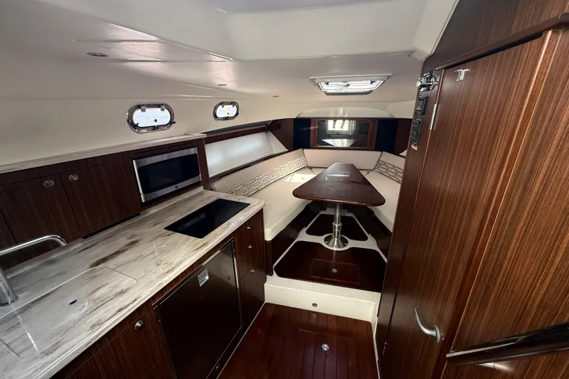  Yacht Photos Pics Luxurious interior of 2022 Pursuit OS 355 Offshore boat with modern kitchen and seating area.