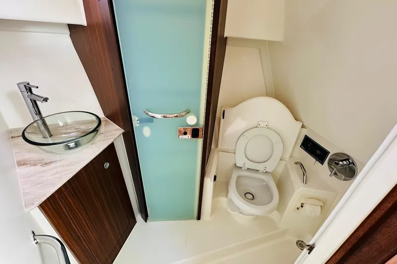  Yacht Photos Pics 2022 Pursuit OS 355 Offshore bathroom with modern sink and toilet.