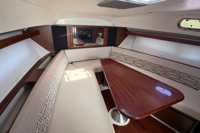  Yacht Photos Pics 2022 Pursuit OS 355 Offshore cabin with elegant seating and wooden table.