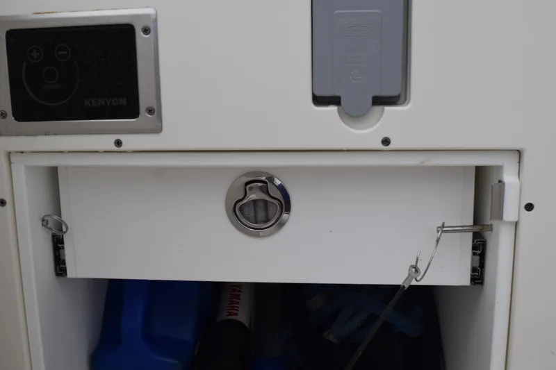  Yacht Photos Pics 2022 Pursuit OS 355 Offshore storage compartment with Kenyon control panel.