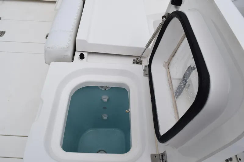  Yacht Photos Pics 2022 Pursuit OS 355 Offshore boat with open storage compartment and cushioned seating.