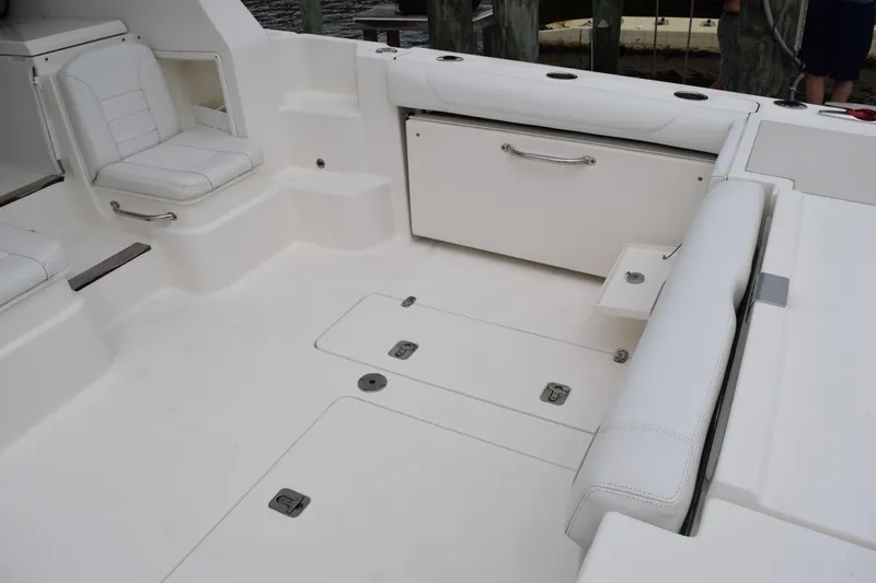  Yacht Photos Pics 2022 Pursuit OS 355 Offshore boat interior with white seating and storage compartments.